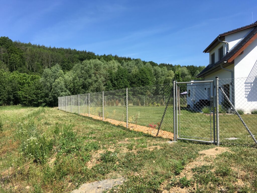 drátěný plot s usazenou brankou u rodinného domu